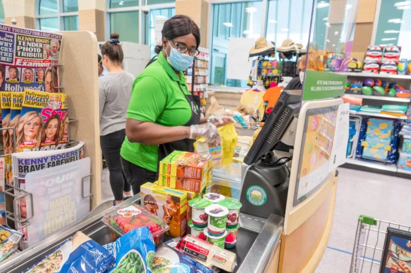 Black woman working at grocery store; Black and Latina women hit hard by job loss