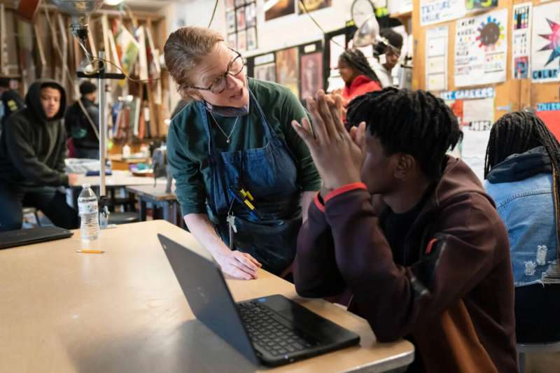 Art teacher speaks with a student