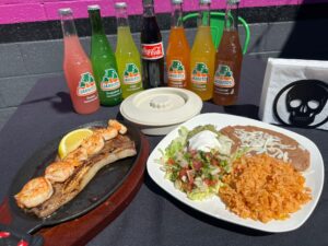 Fajitas and sodas on a patio table.