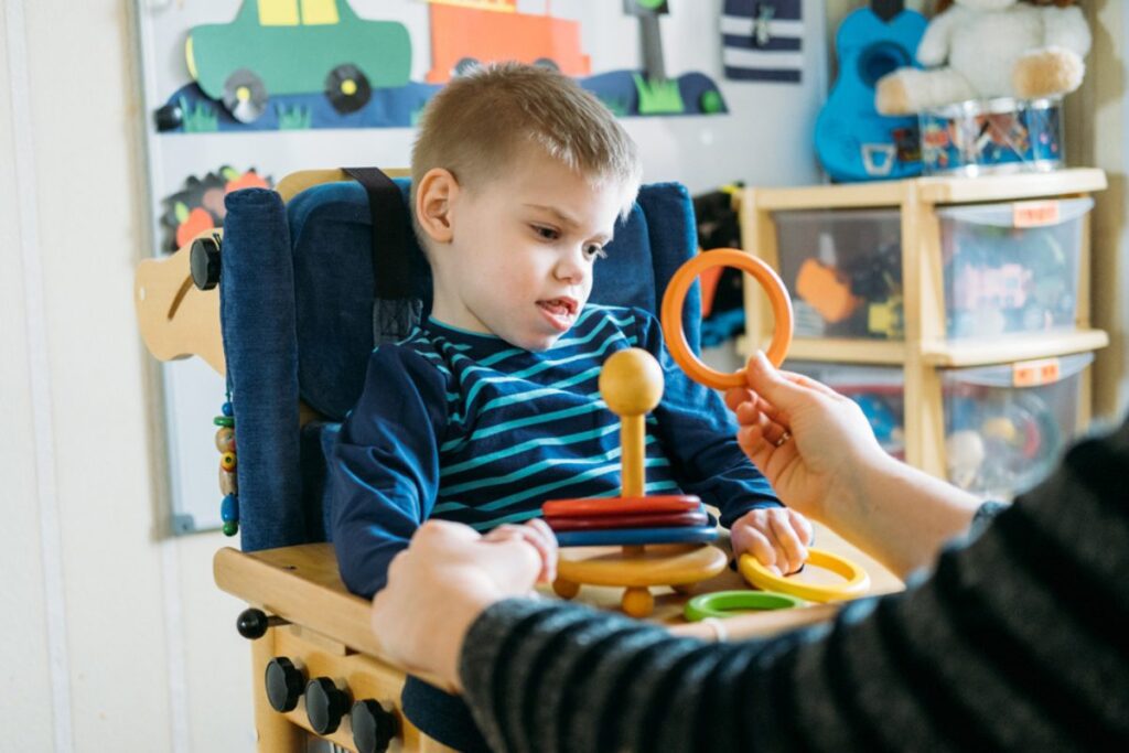 Child playing with toys with an adult's guidance