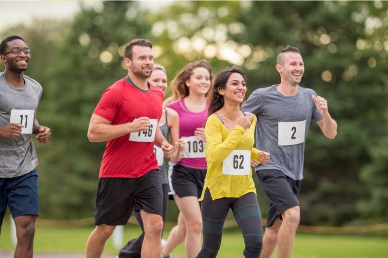 Six people in running bibs running a 5k race.
