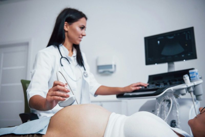 Female doctor giving female patient an ultrasound.