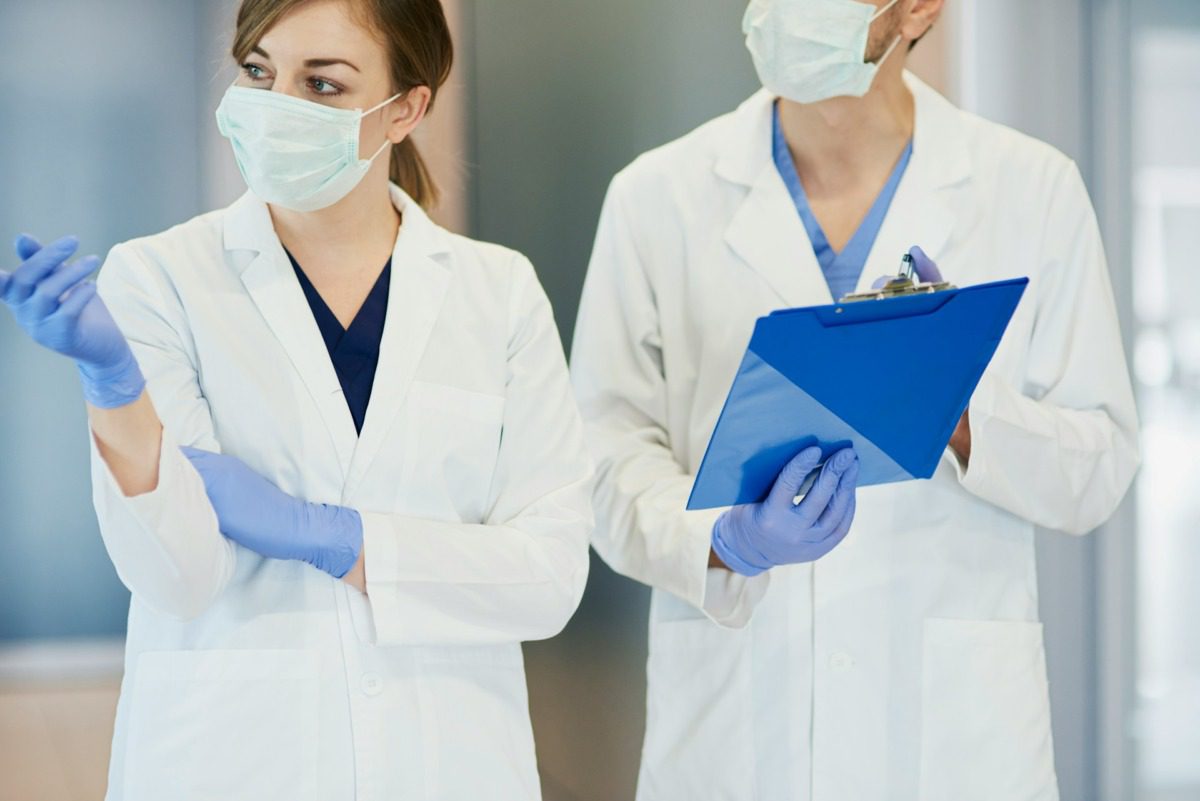 Two doctors wearing masks in a hospital.