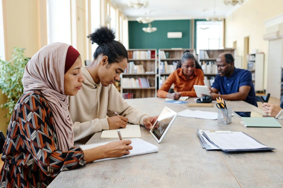 A group of people studying around a table in a library.