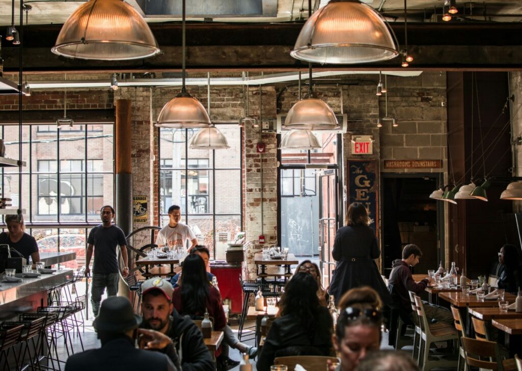 Interior of restaurant where people are walking about and eating.