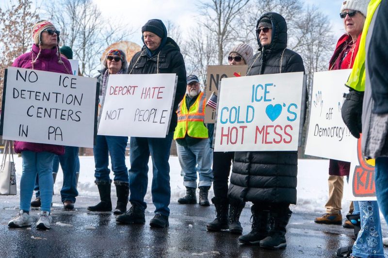 Demonstrators listen to a number of speakers during a Presidents' Day No Kings rally and protest at Druckenmiller Park.