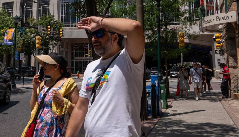Photo of man using his arm to block the sun from his eyes