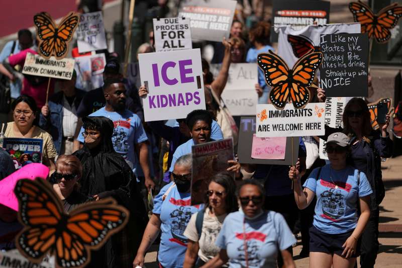 Immigrant rights supporters with signs demonstrating against mass deportations on May Day outside the federal courthouse in Philadelphia.